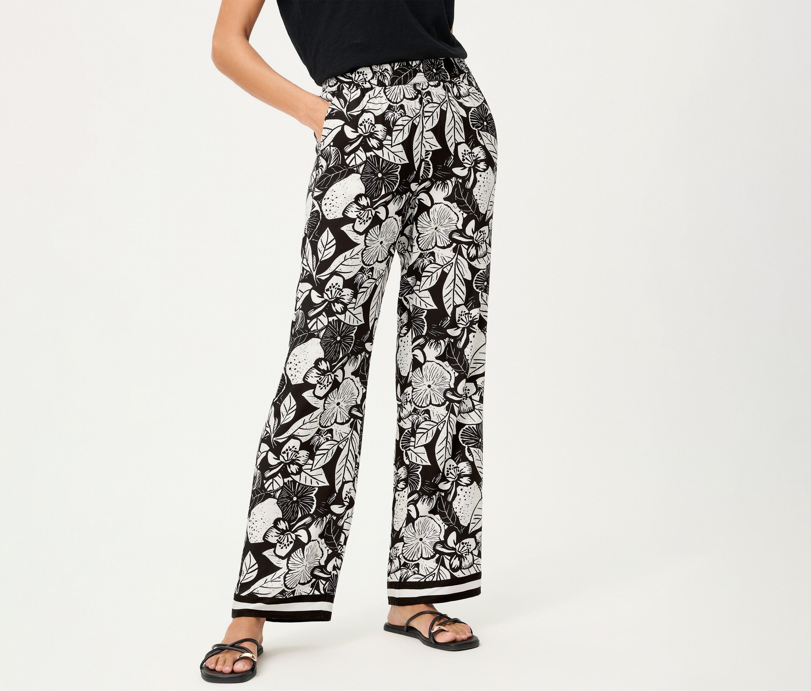 Virágmintás Olsen bőszárú nadrágot és fekete szandált viselő nő.