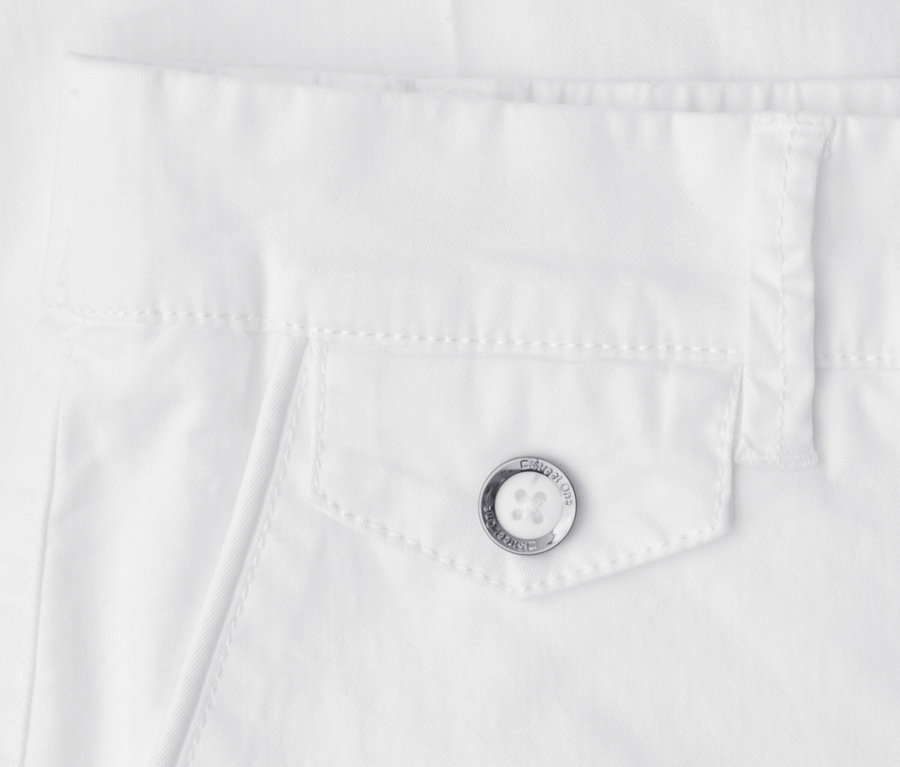 Fehér Street One Chino nadrág közelképe, amely egy fedeles zsebet mutat ezüst gombbal, melyre a „STREET ONE CASUAL WEAR” felirat van gravírozva, a derékpánt alatt.