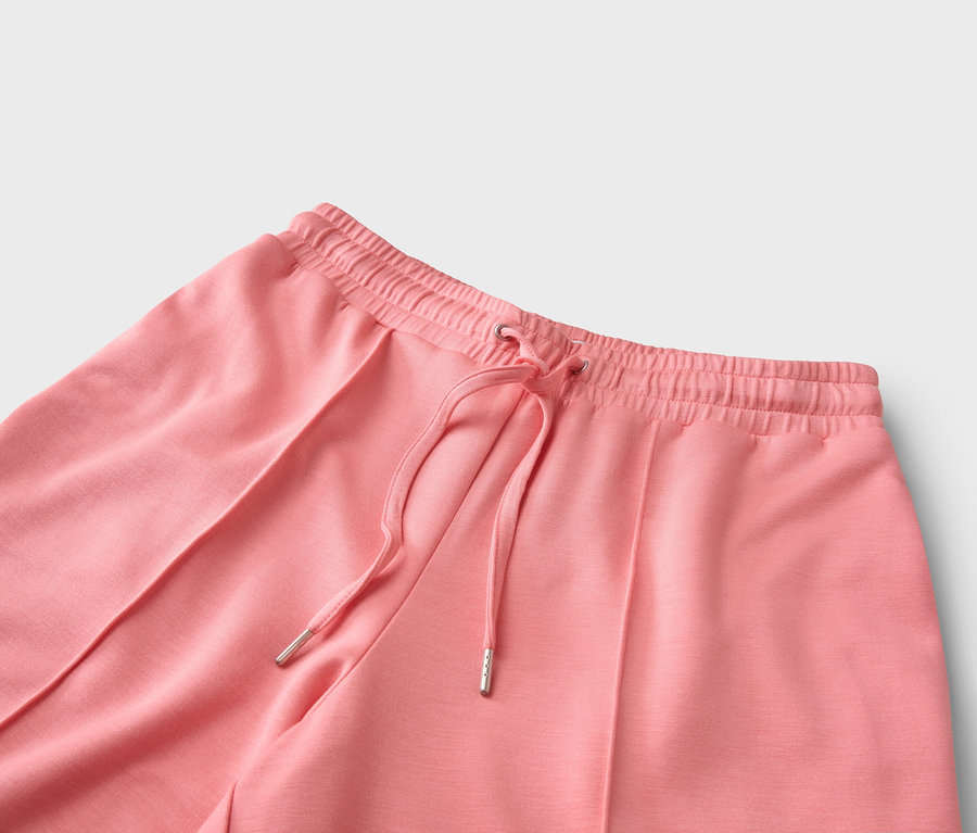 Korall színű, húzózsinóros nadrág közeli képe.