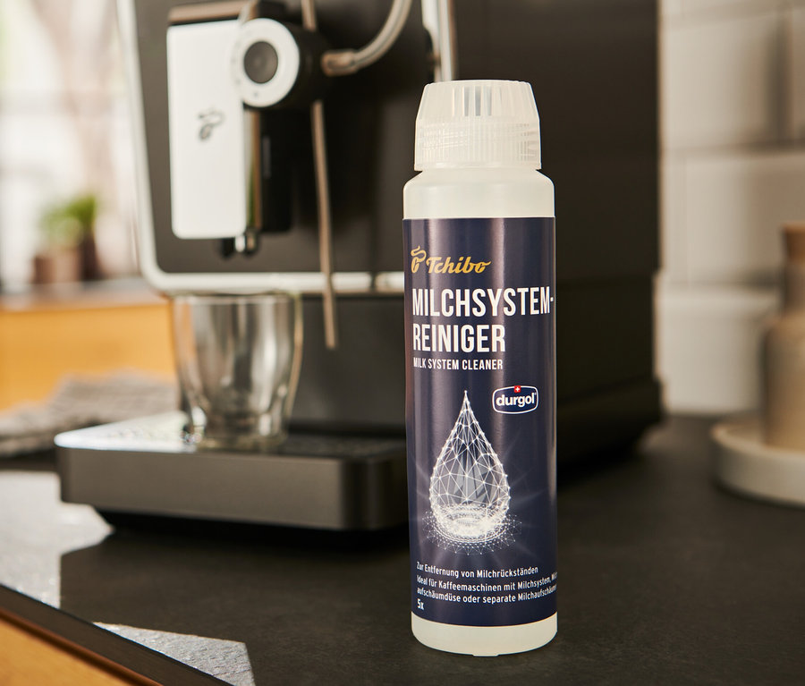 A durgol® tejrendszer tisztító	, 250 ml egy kávéfőző mellett áll.