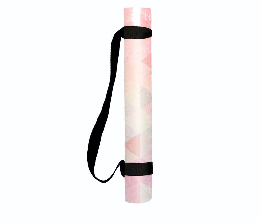Összetekert Yoga Design Lab Travel Combo jógamatrac »Tribeca«, 1,5 mm, rózsaszín, fehér és szürke geometrikus mintával, fekete hordozópánttal rögzítve.
