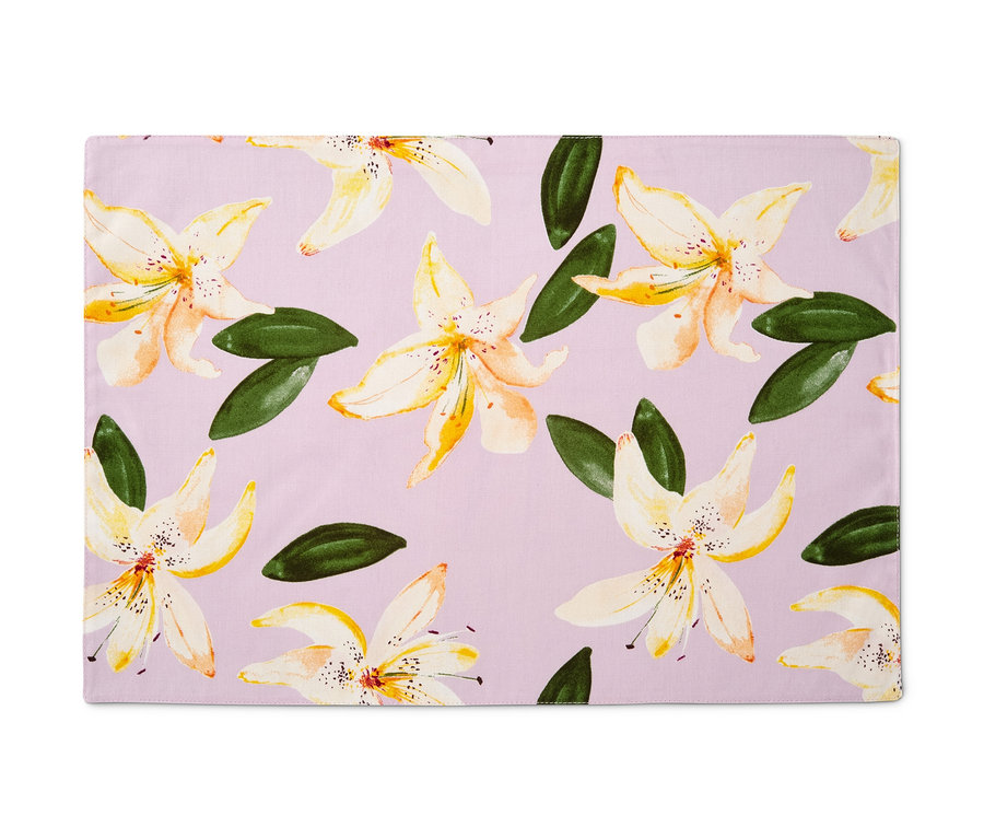 Négy kétoldalas, virágmintás tányéralátét lila háttérrel.