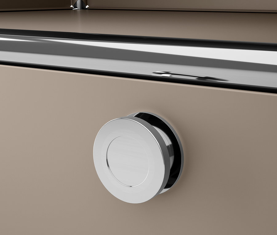 Közelkép egy szürkésbarna »CN3« fém komódról, krómozott, kerek fogantyúval.