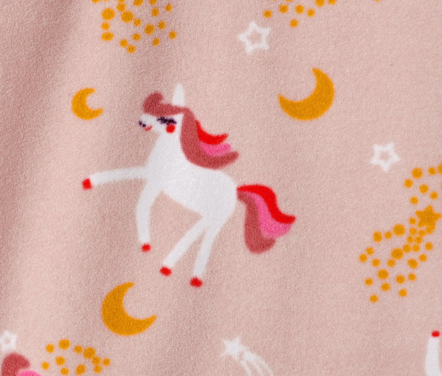 Egy rózsaszín hátterű, unikornis, csillag és hold mintás gyerek polárfelső közeli képe.