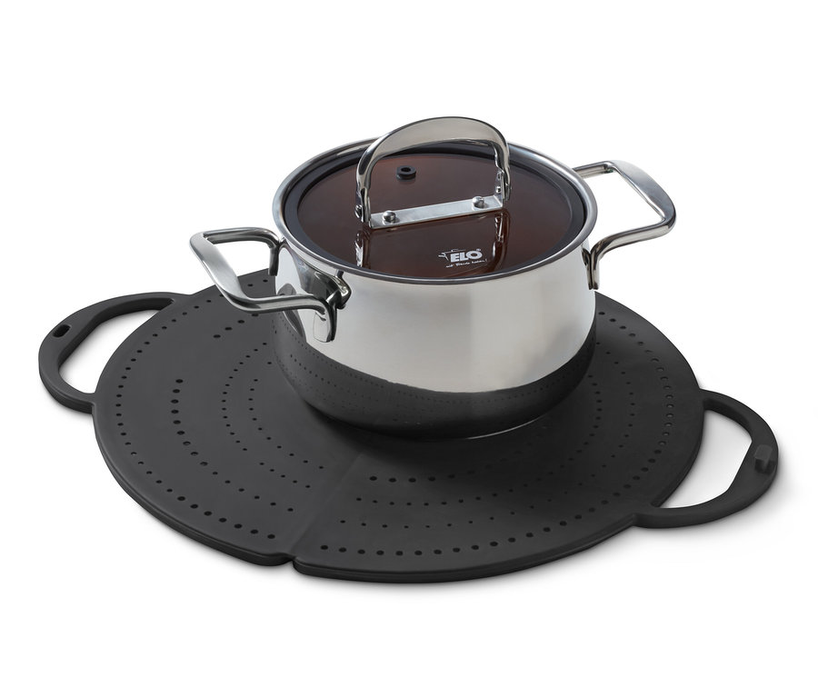 Egy rozsdamentes acélból készült fedővel ellátott edény egy fekete 4 az 1-ben konyhai mindenesen áll.