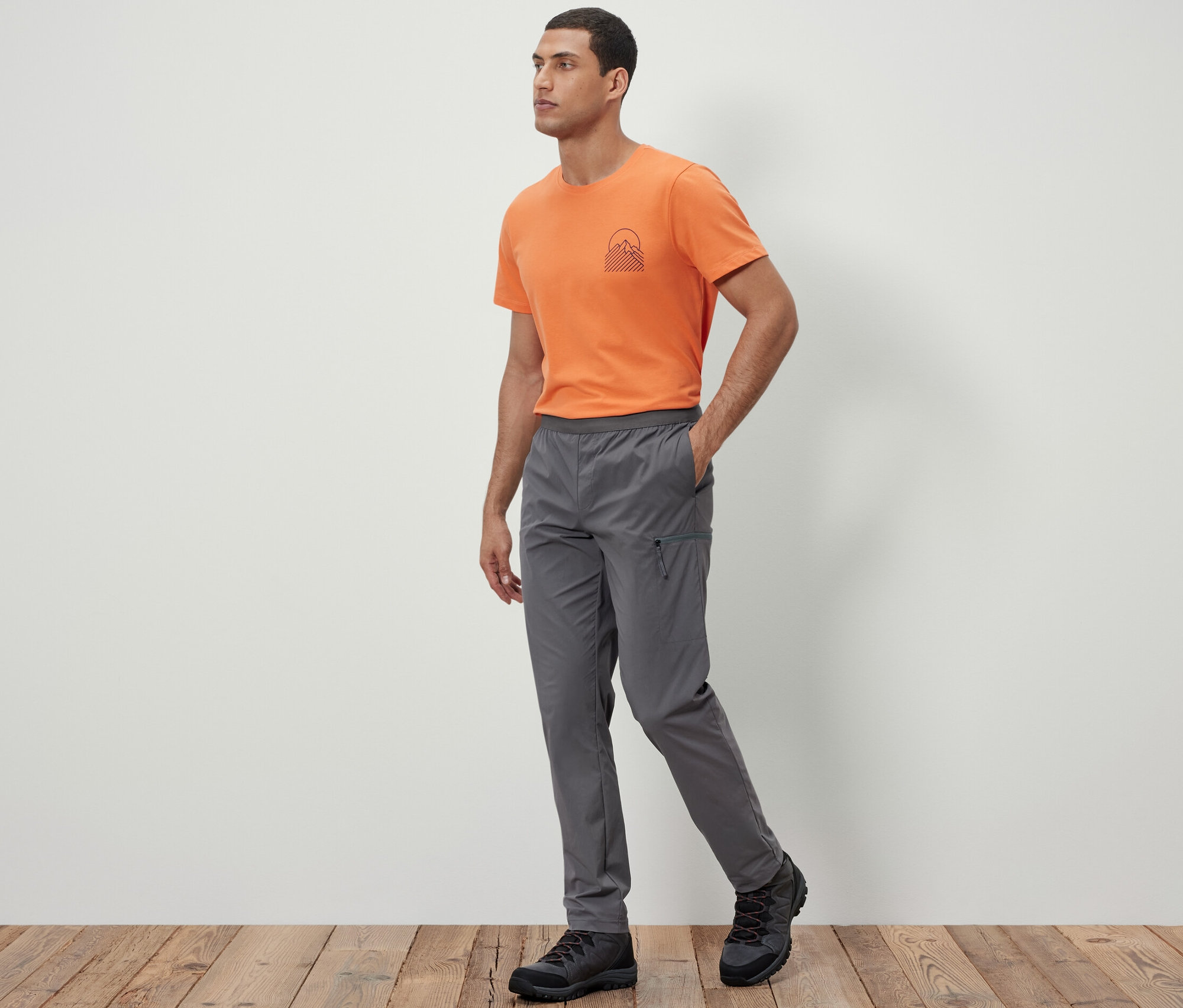 Férfi sétál, Könnyű funkcionális nadrágot visel.