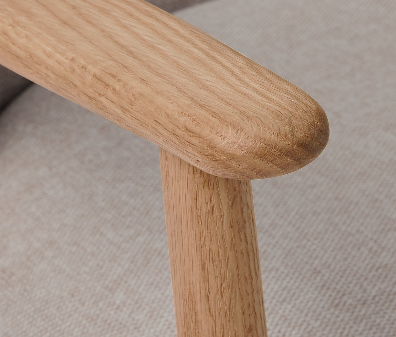 Közeli kép egy fa karfás szék karfájáról.