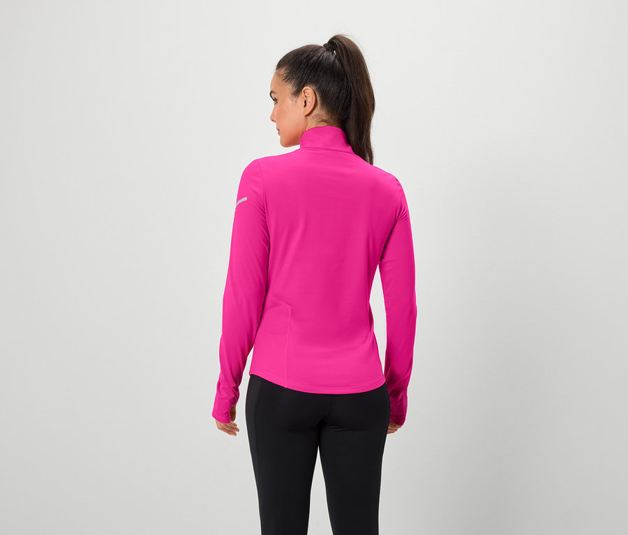 Hátulról látható nő rózsaszín, hosszú ujjú felsőt és fekete leggingst visel.