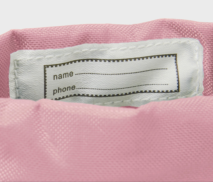 Egy virágmintás gyerek gumicsizma részlete, név címkével.