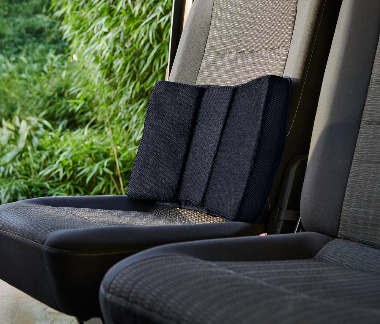 Egy fekete deréktámasz egy autósülésen.