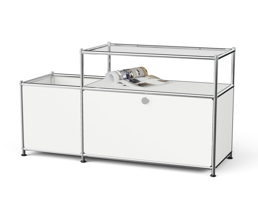 Fehér, moduláris tárolórendszer króm kerettel és üvegpolcokkal, a felső polcon egy feltekert magazin.