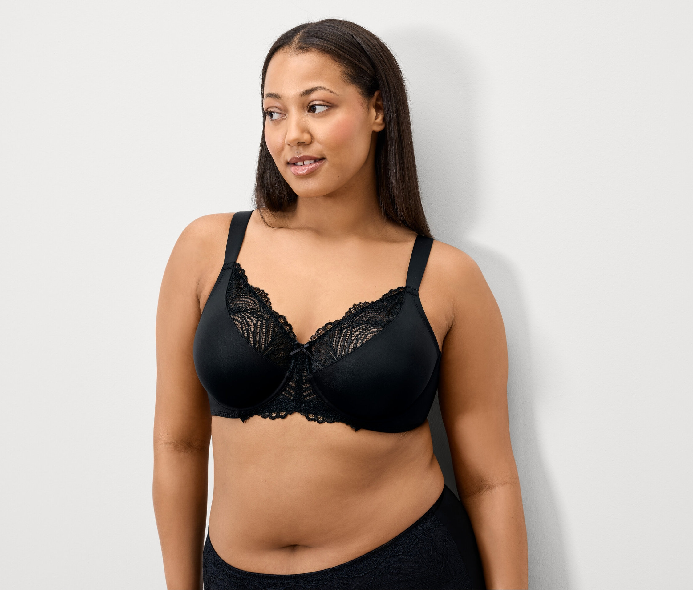 Nő visel fekete csipkés melltartót.