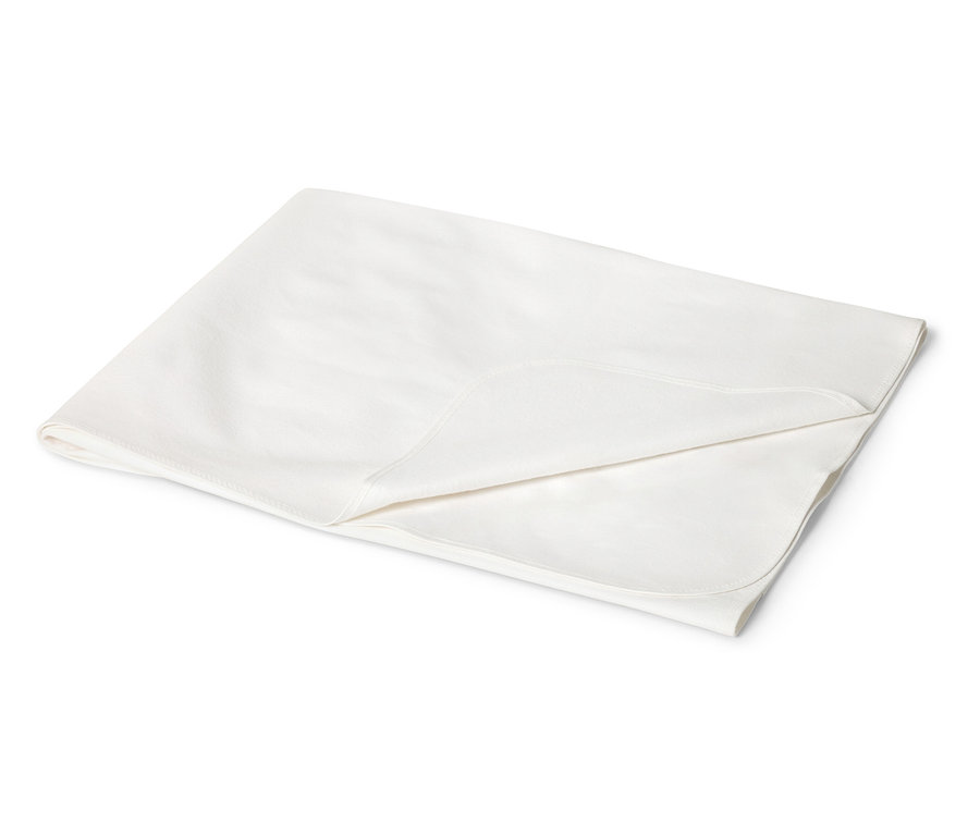 Közeli kép egy összehajtott, krémszínű, lekerekített sarkú babatakaróról fehér háttér előtt.