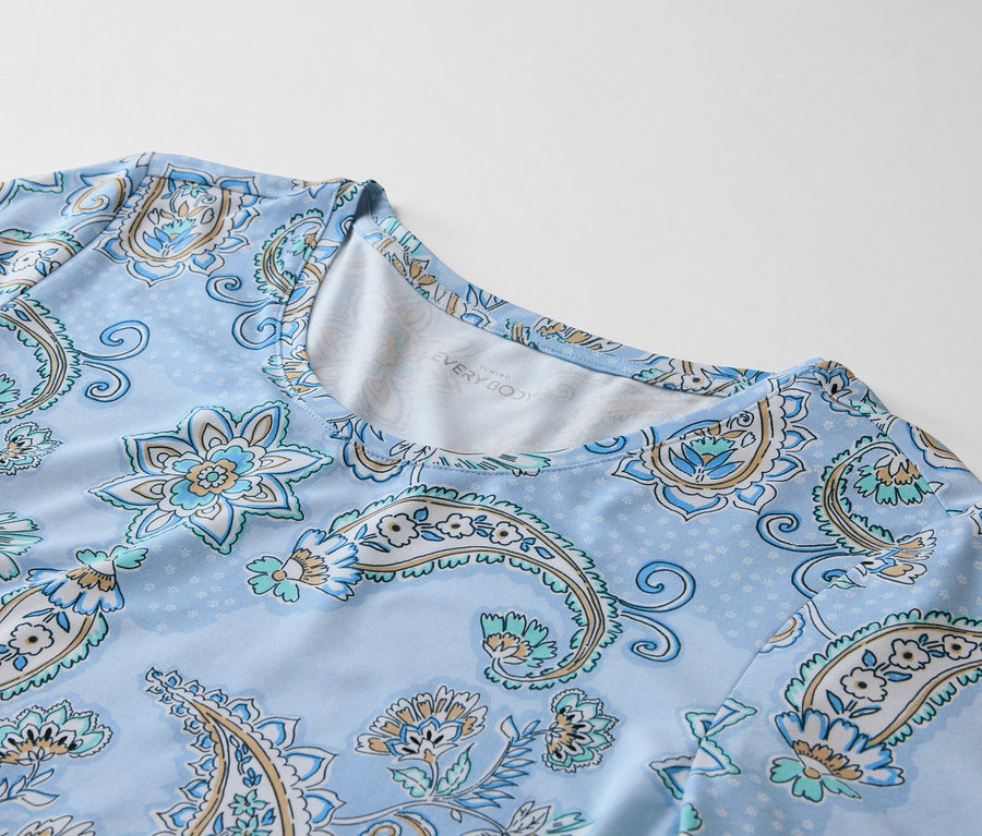 Egy világoskék felső közeli képe halványkék paisley mintával.