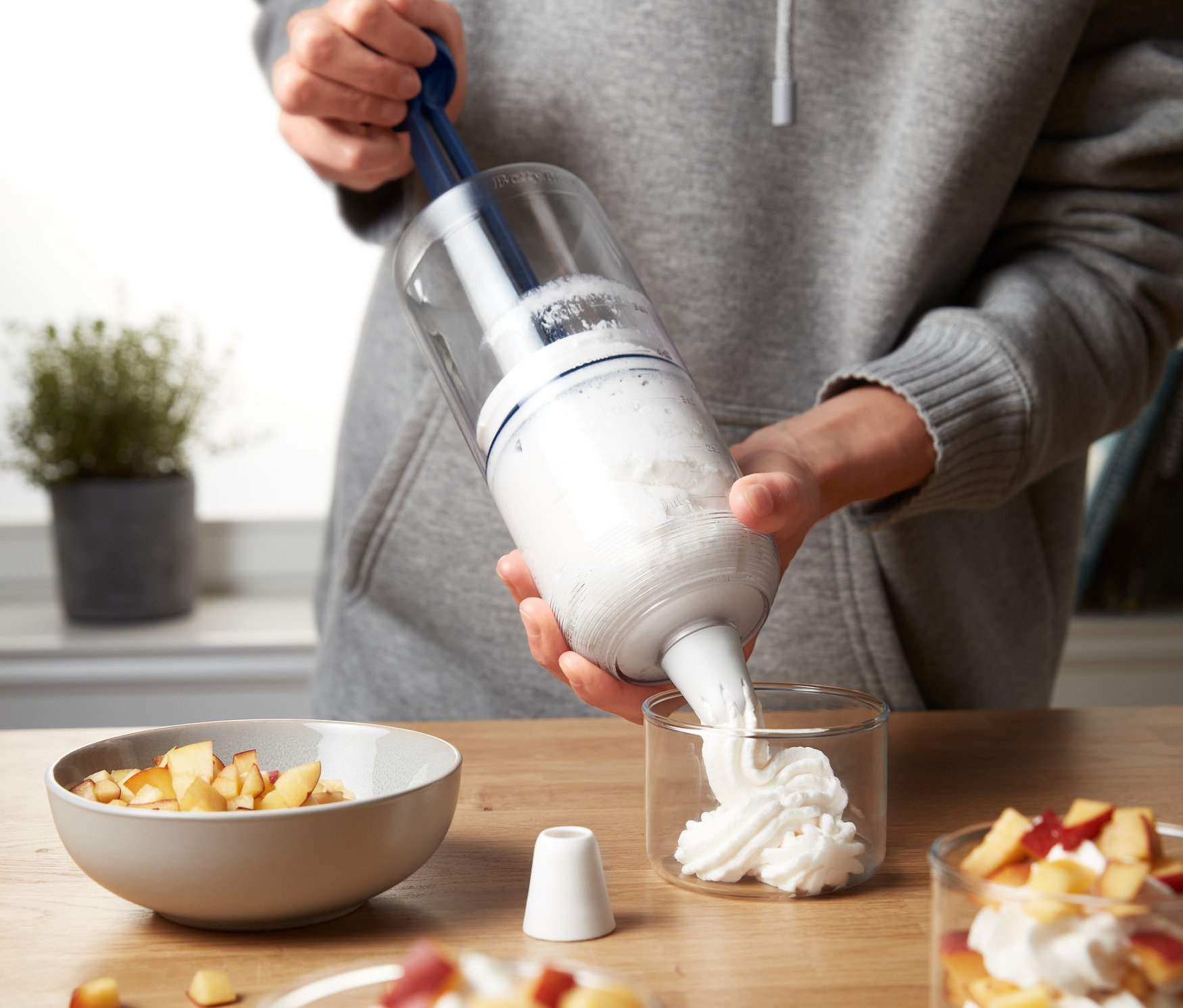 Személy tölti a desszertet egy 2 az 1-ben krémdesszert készítő és kinyomóval.