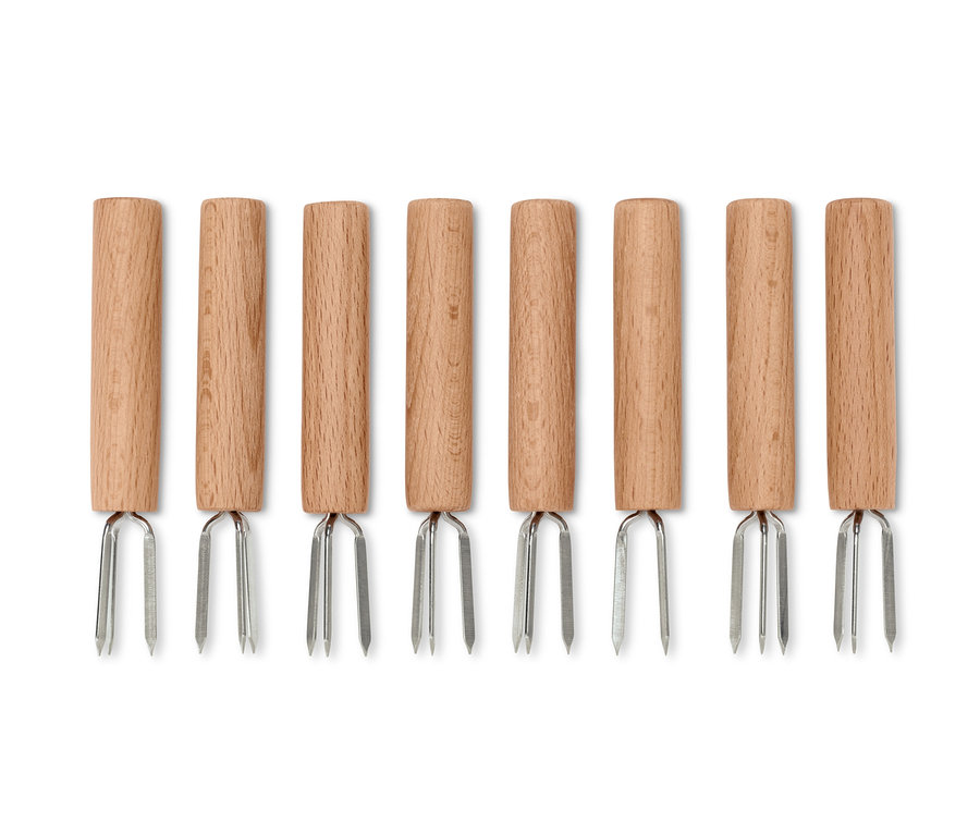 Nyolc kukoricacső tartó fa nyéllel és ezüst színű villákkal egy sorban elrendezve.