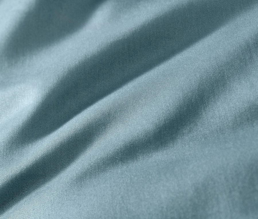 Kék pamutszatén ágyneműgarnitúra közelről.