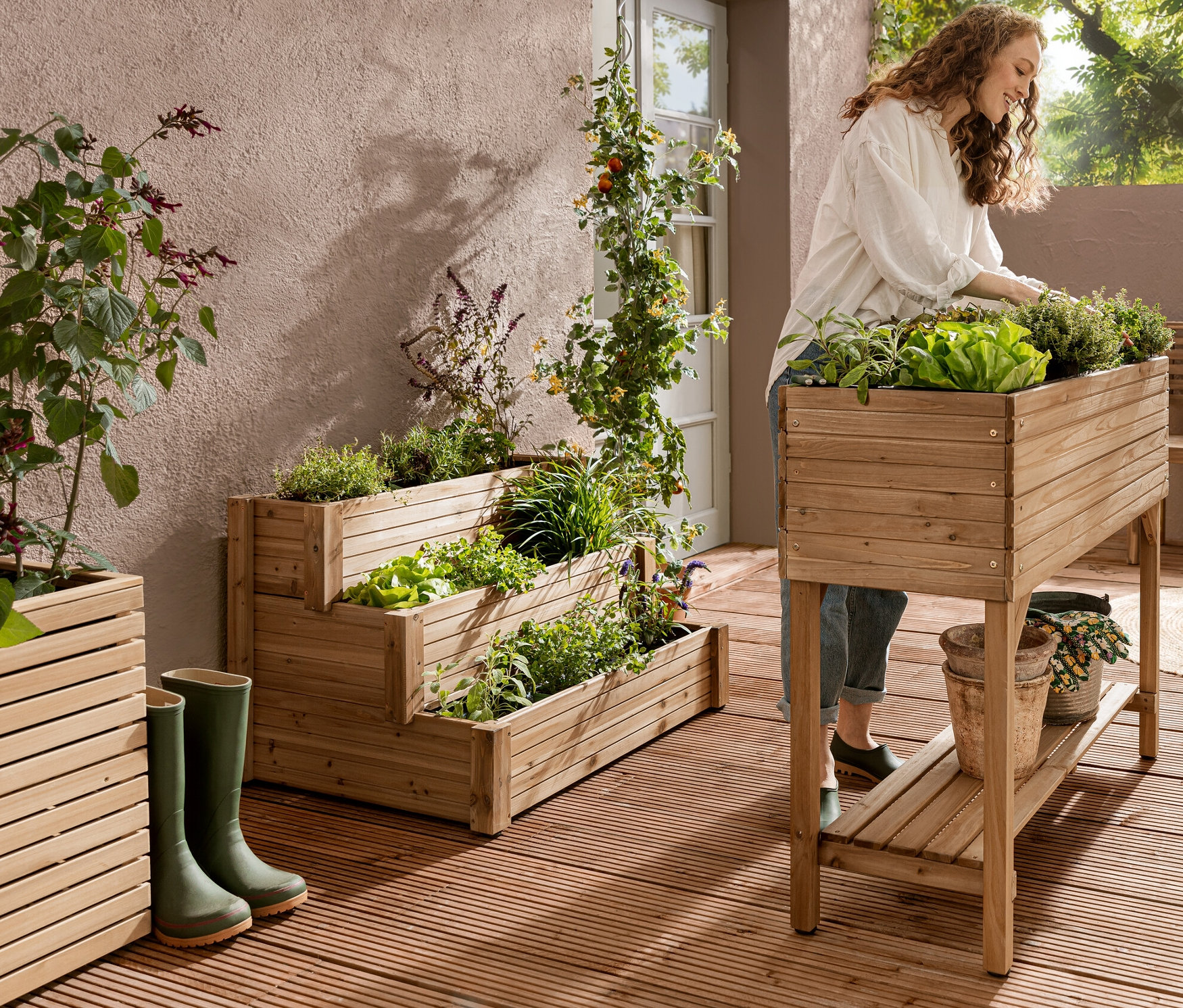 Egy nő a »Tinus« magaságyáson dolgozik, melyen polc található. A háttérben egy »Tinus« 3 szintes lépcsős magaságyás látható.