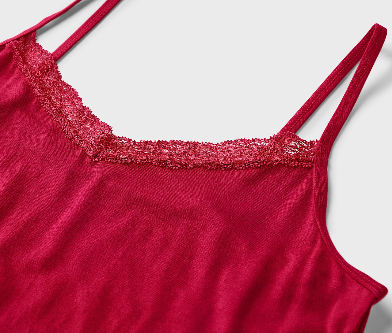 Egy piros, csipkés nyakú atléta részletfotója.