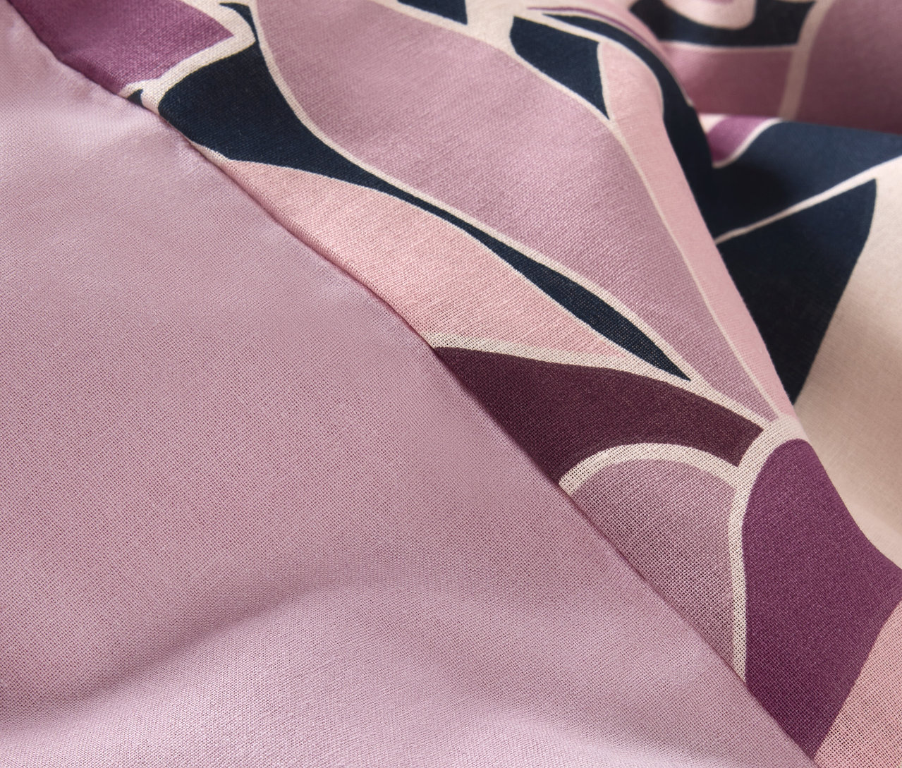 Egy normál méretű, lila virágmintás renforcé ágynemű részlete.