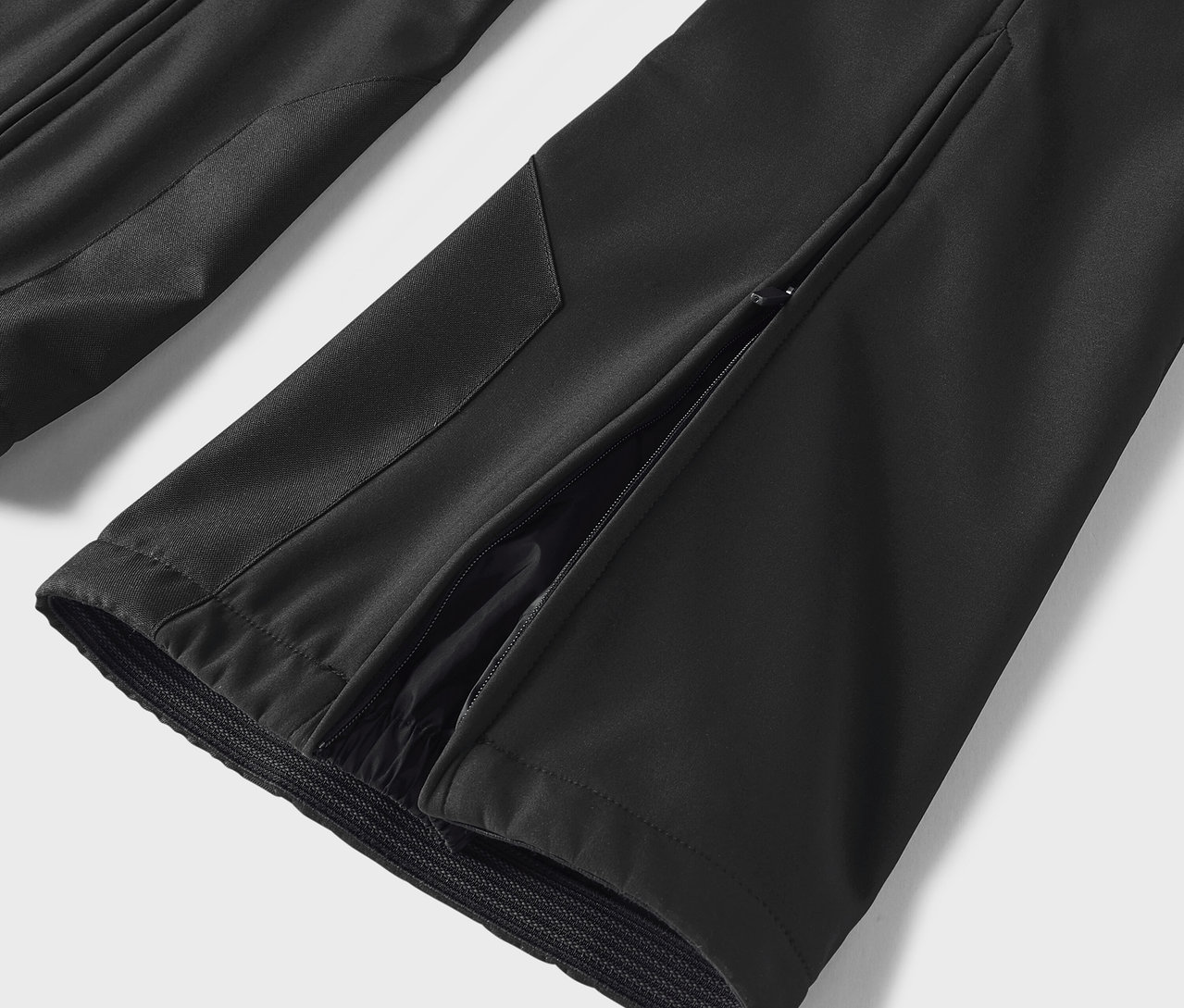 Egy fekete nadrág részlete oldalsó sliccel.