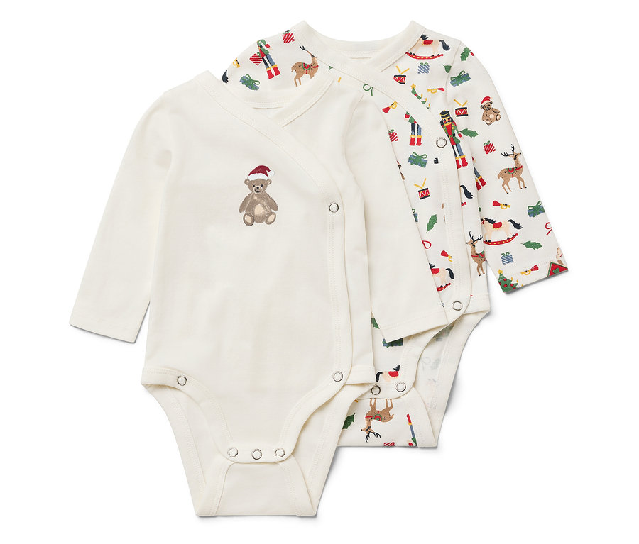 Két fehér, hosszú ujjú body. Az egyiken barna mackó van piros sapkával, a másikon karácsonyi minta.