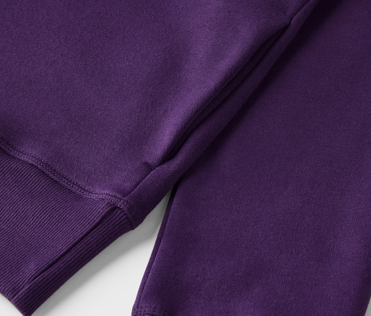 Lila színű pulóver részlete bordázott szegéllyel.