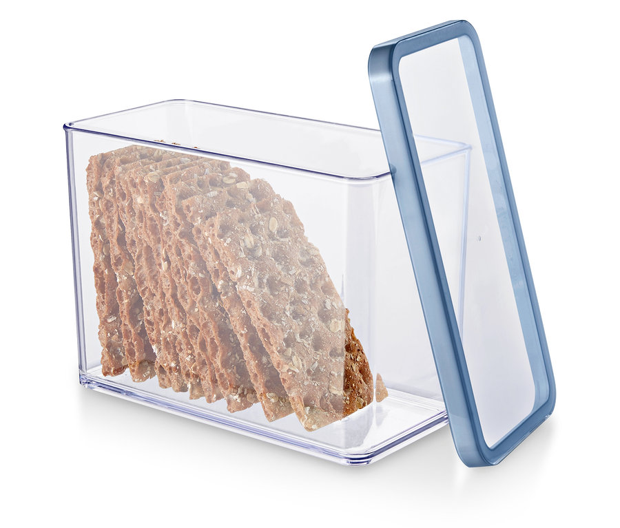 Egy kék szélű, átlátszó tartályban teljes kiőrlésű kekszek vannak.