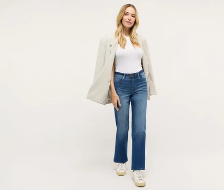 Nő visel egy Angels denim »Lara City« straight fit farmernadrágot, egy fehér pólót, egy blézert és tornacipőt.