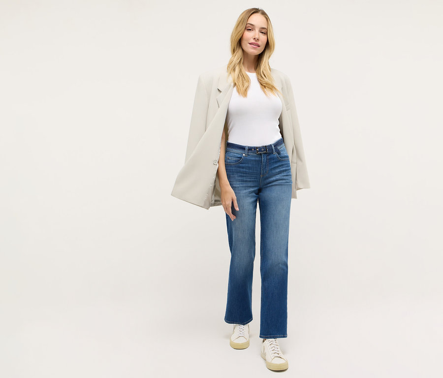 Nő visel egy Angels denim »Lara City« straight fit farmernadrágot, egy fehér pólót, egy blézert és tornacipőt.