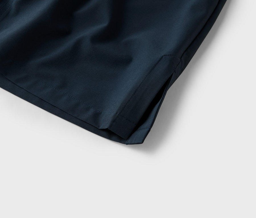 Egy sötétkék rövidnadrág zsebének közeli képe fehér háttérrel.