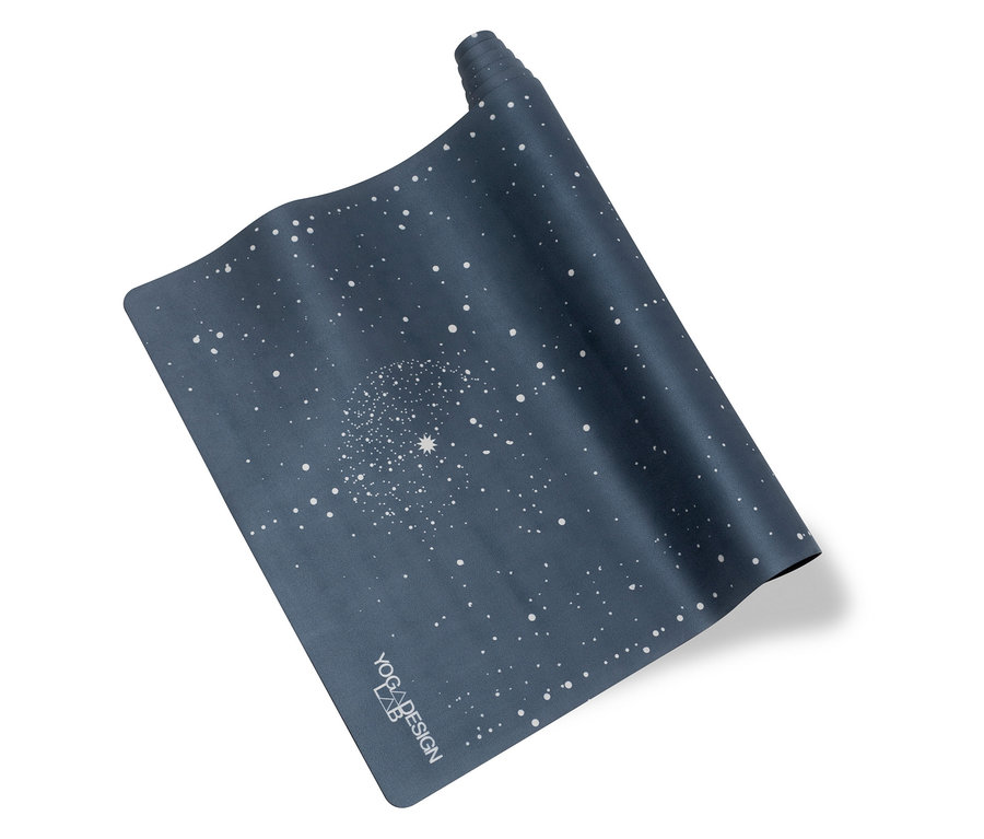 Egy részben feltekert, sötétkék jógaszőnyeg fehér pöttyös mintával.