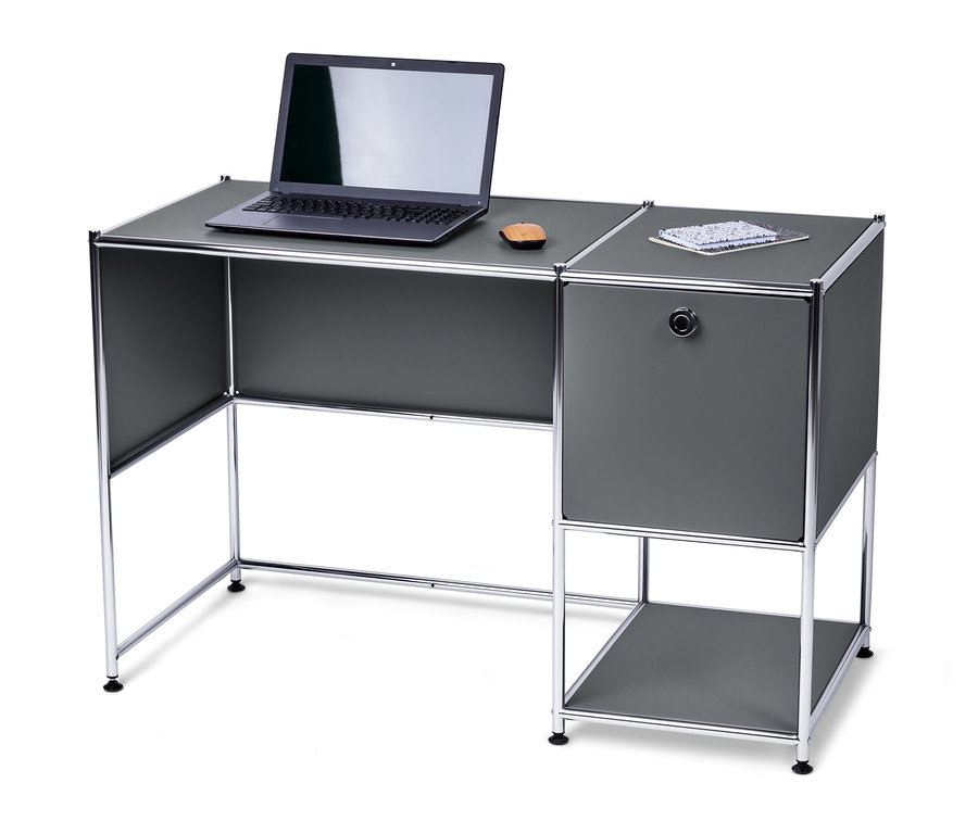 Egy szürke fém íróasztalon egy laptop és egy jegyzettömb látható.