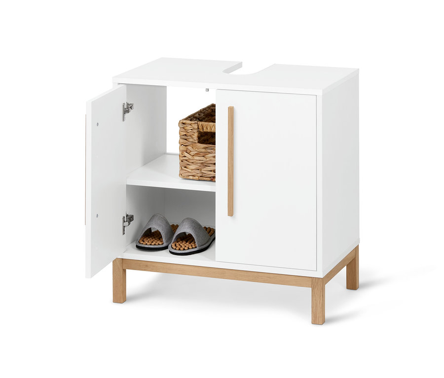 Egy nyitott, fehér Eklund mosdó alatti szekrény kosárral és papuccsal a belsejében.