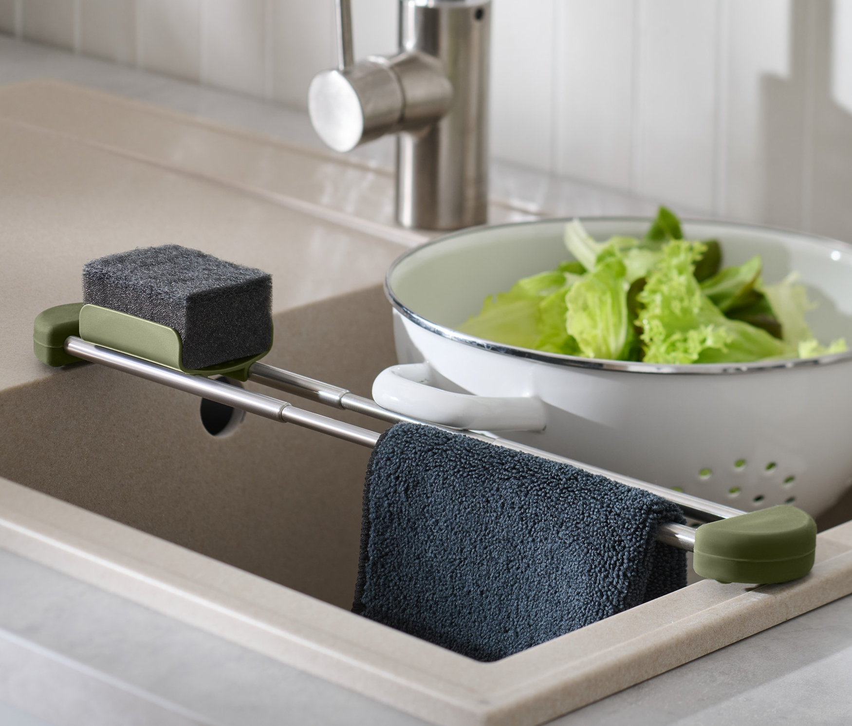 A mosogatótálcában egy kihúzható mosogató-rendszerező található szivaccsal, ronggyal és salátával egy szűrőedényben.