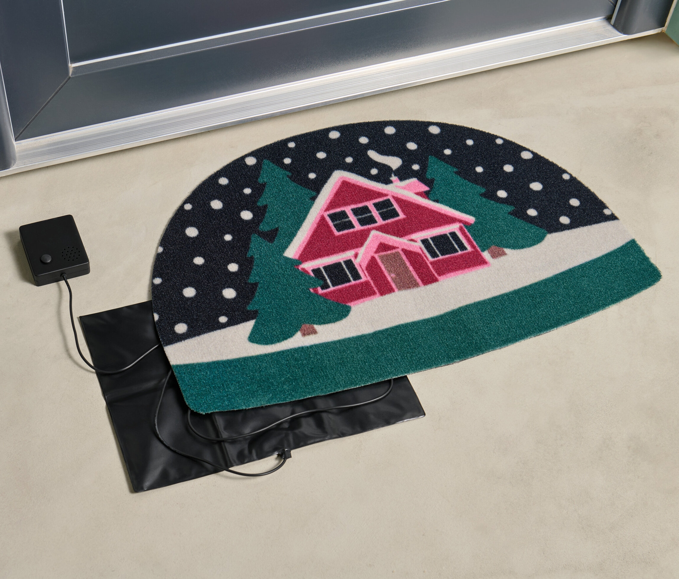 A lábtörlőhöz való, érzékelős karácsonyi zenélő szerkezet az ajtó mellett van.