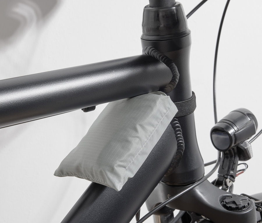 Szürke kerékpáros bevásárlótáska a kerékpár vázához rögzítve.