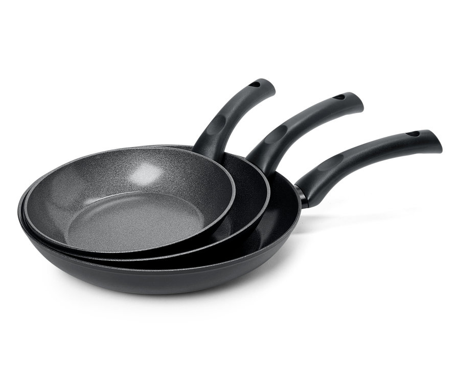 Három különböző méretű fekete serpenyő egymásra rakva.