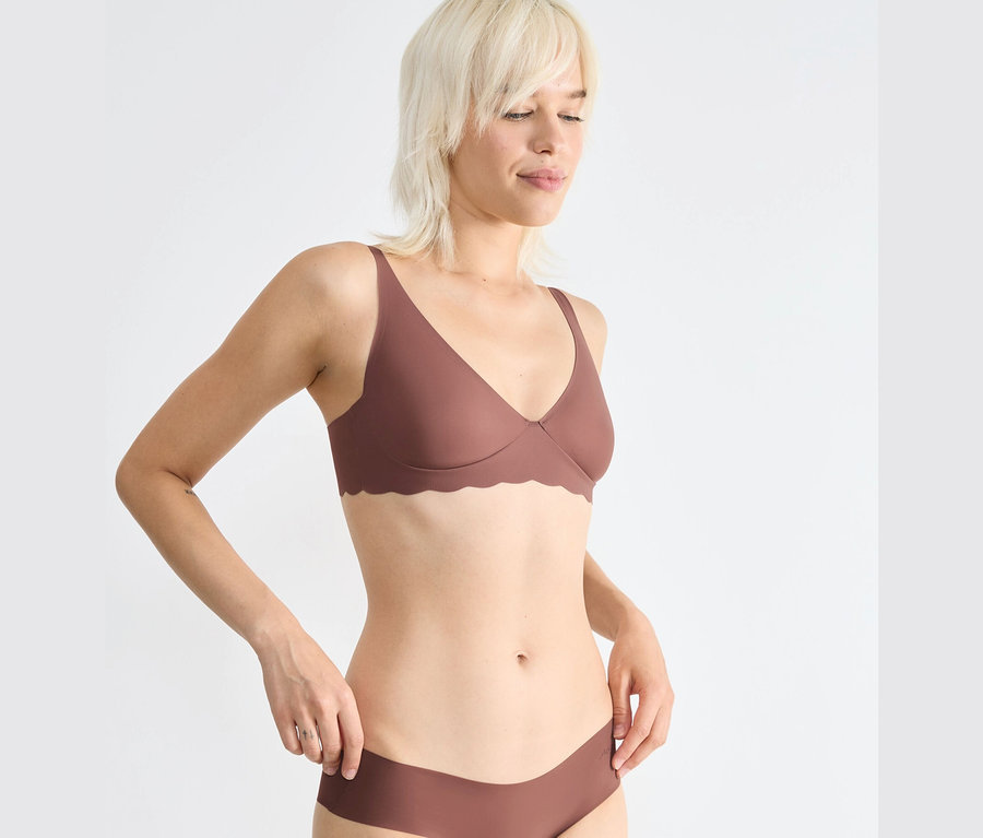 Nő pózol egy sloggi ZERO Microfibre 2.0 puha melltartóban.