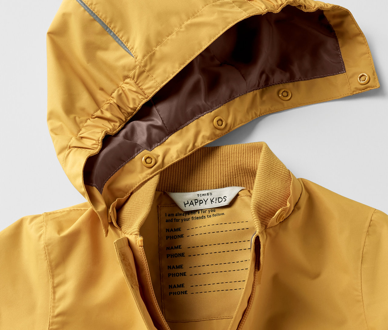 Egy sárga, kapucnis eső elleni kezeslábas gyerekeknek részletfotója.