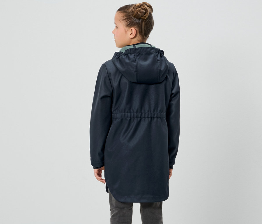 Egy lány háttal áll, és egy Kinder-Softshellmantel-t visel.