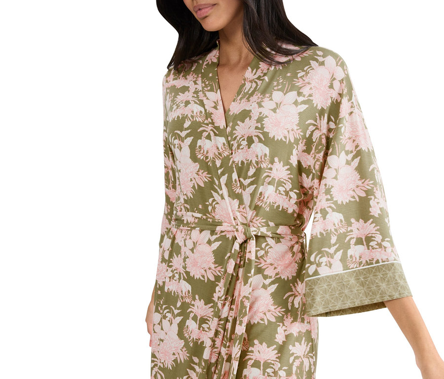 Nő visel zöld és rózsaszín virágos köntöst.