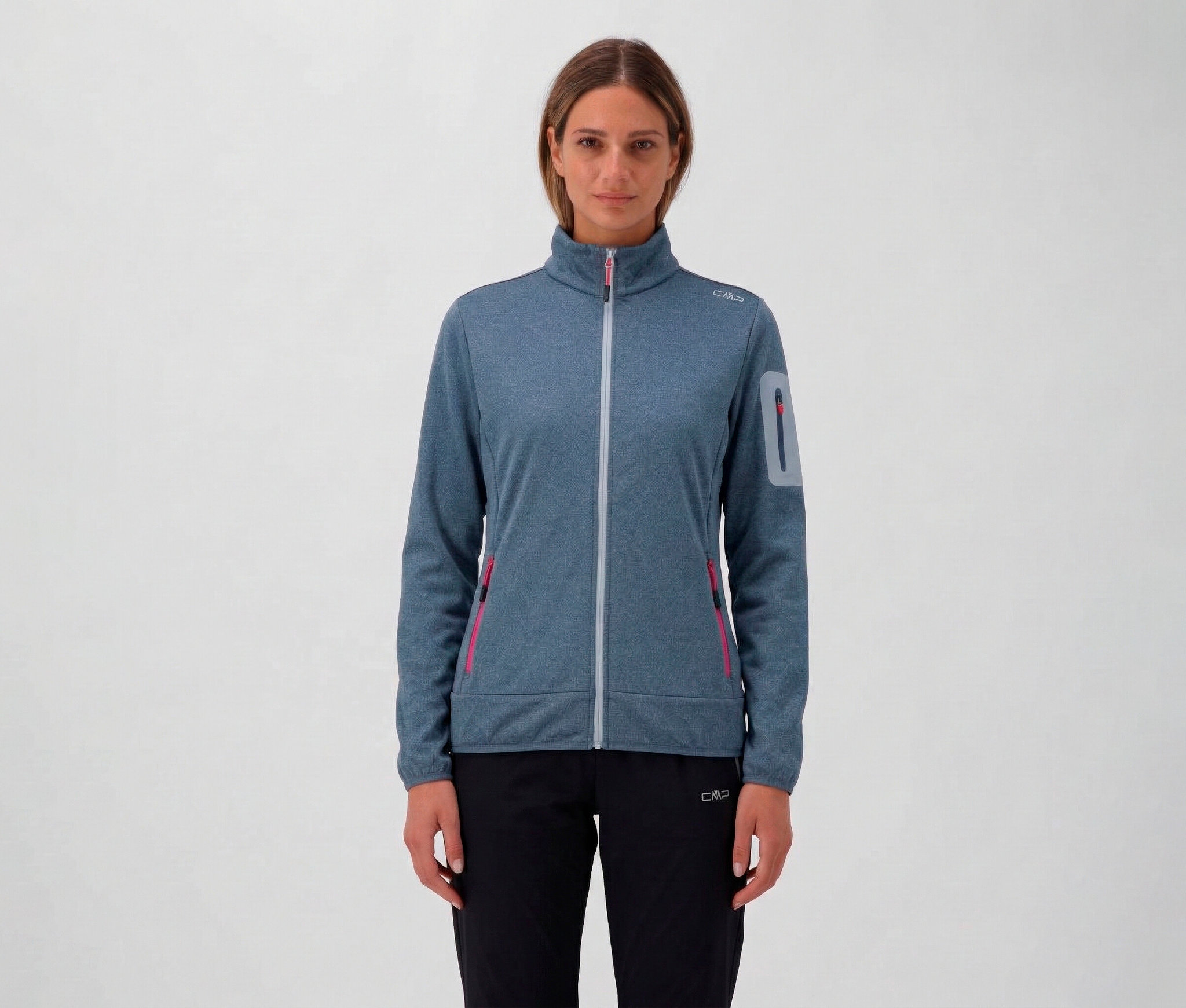 Nő fekete nadrágban és kék CMP női dzsekiben cipzárral és zsebekkel.