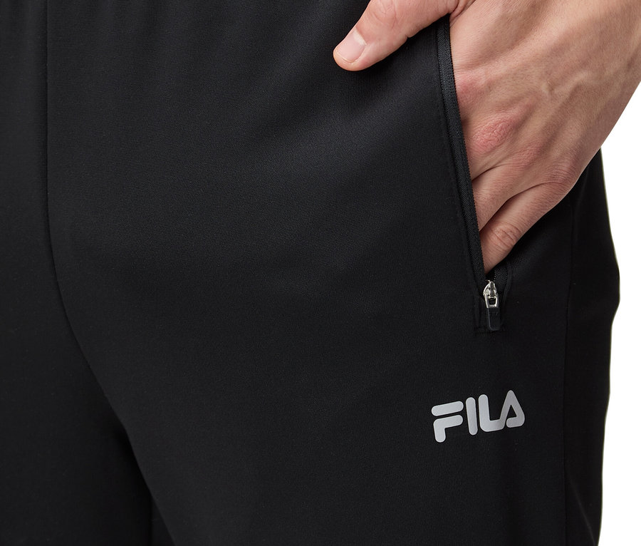 Férfi teszi a kezét egy fekete FILA melegítőnadrág zsebébe.