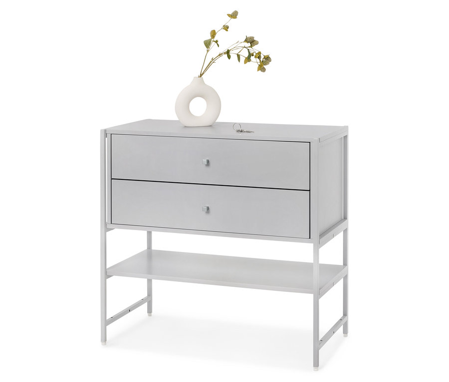 Szürke komód két fiókkal és egy polccal, rajta egy fehér váza növényekkel.