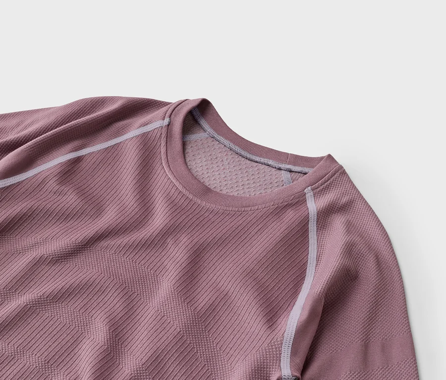 Mauve hosszú ujjú sportpóló bordázott és geometrikus textúrákkal, világosszürke varrással a raglán ujjakon és a galléron.