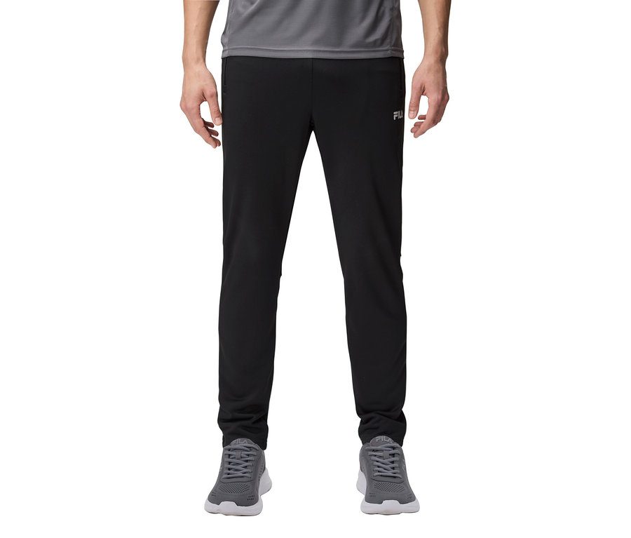 Férfi fekete melegítőnadrágot és szürke tornacipőt visel.