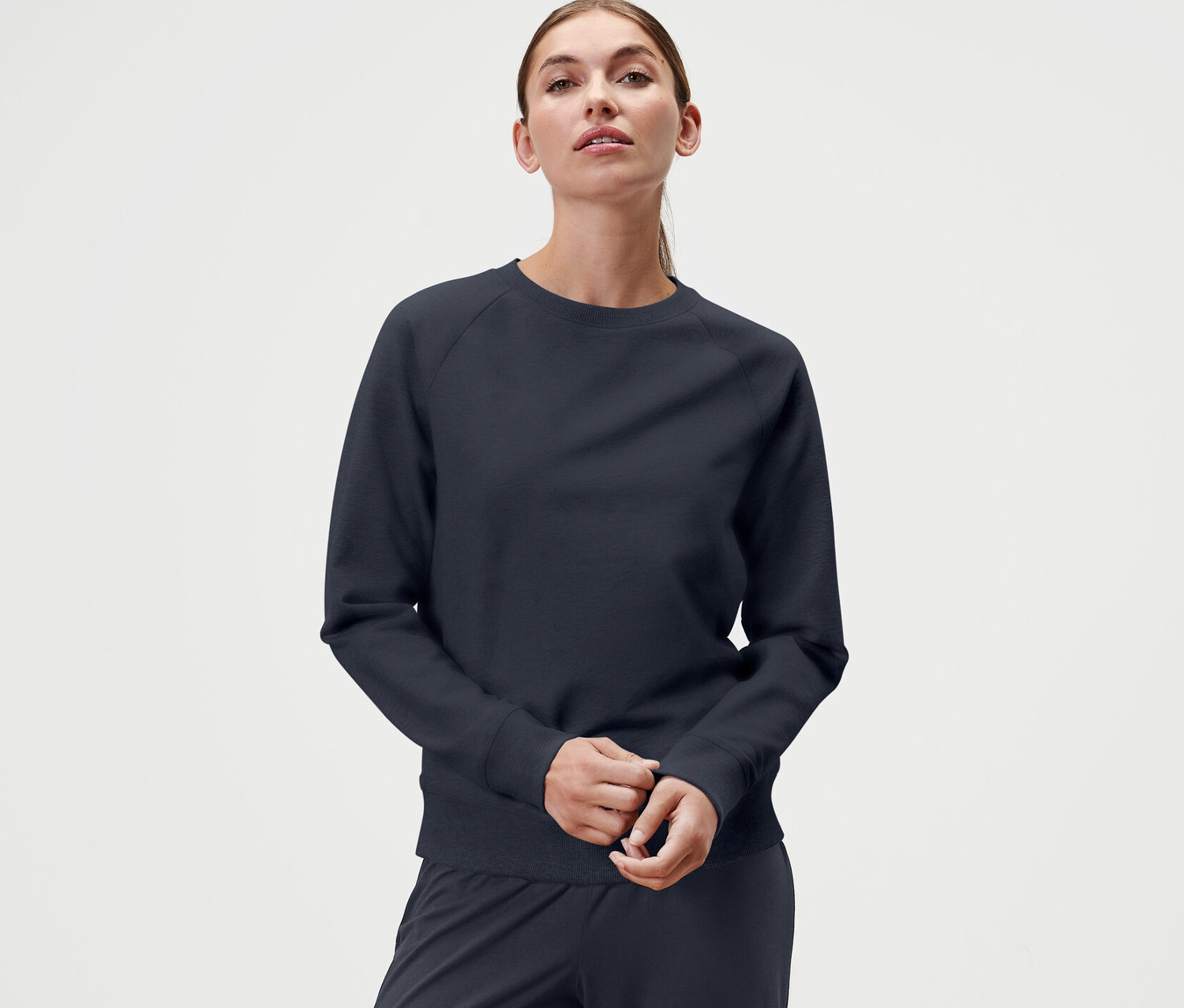Nő visel egy sötétkék női hosszú ujjú jógafelsőt.