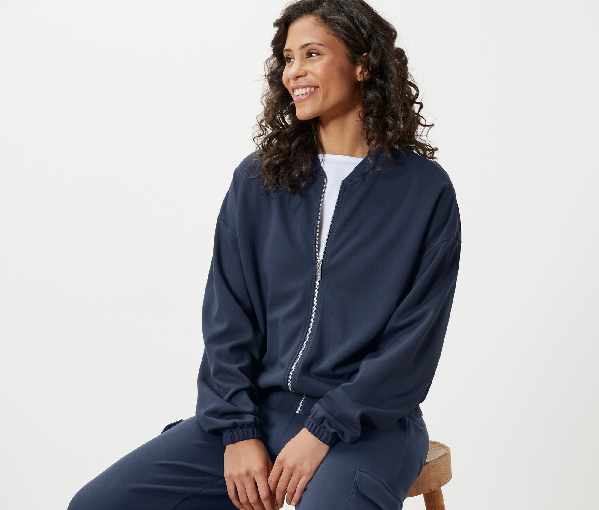 Nő ül és kék szabadidőfelsőt visel.