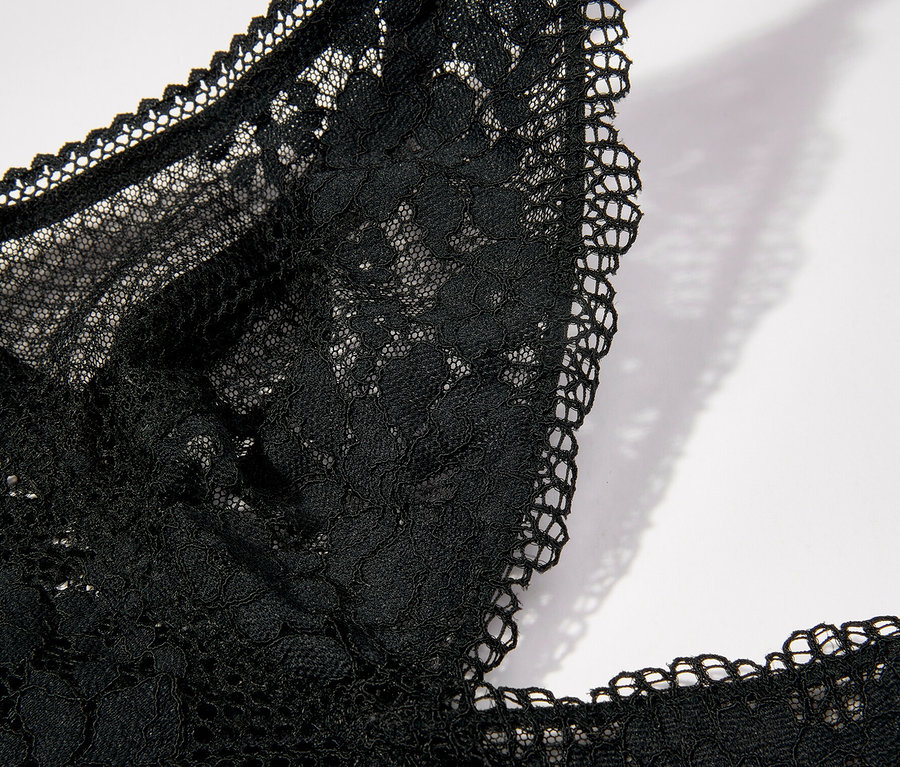 A fekete, merevítő nélküli, háromszög alakú Passionata »Nina« melltartó részletgazdag képe csipkéből.